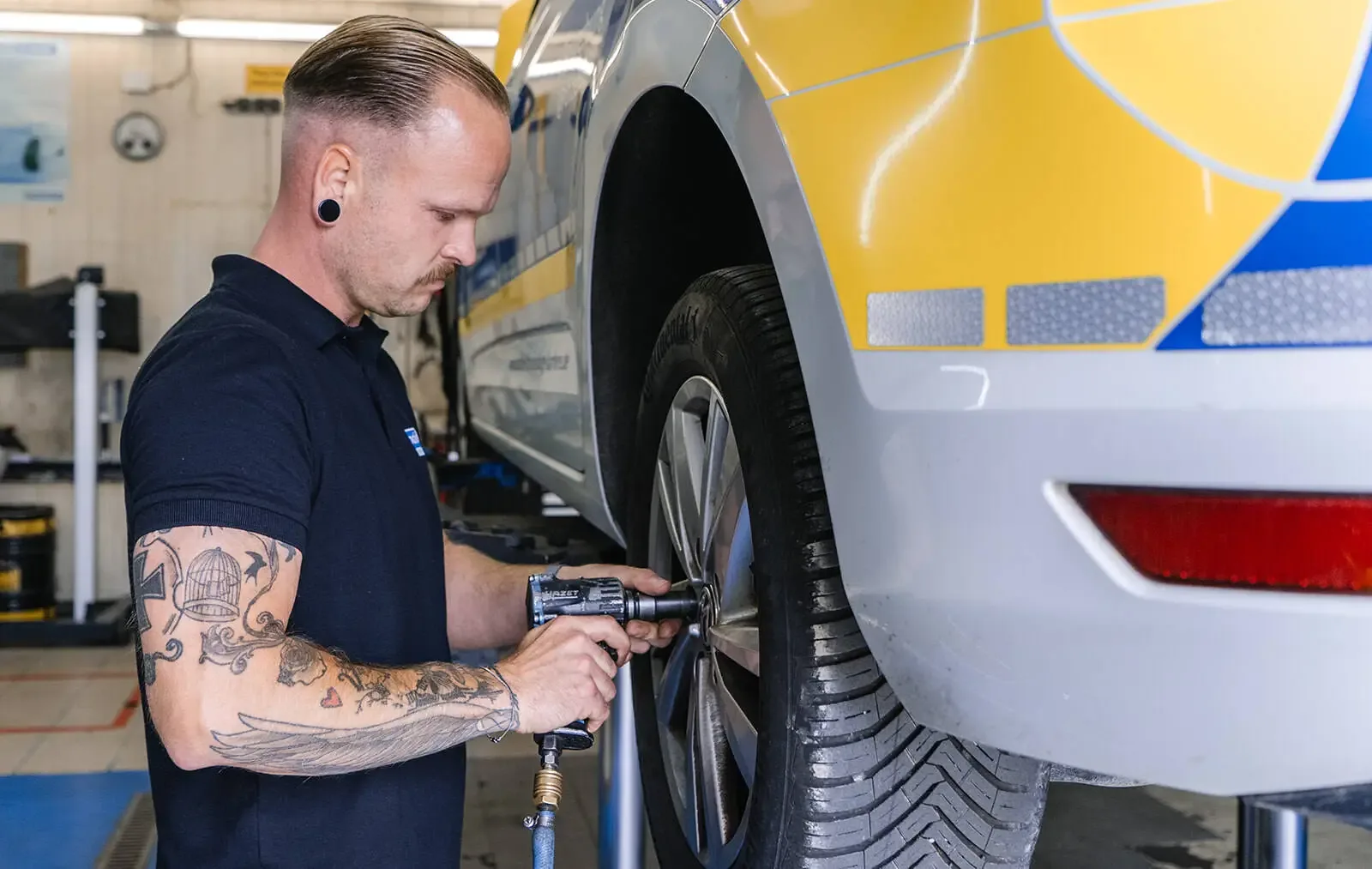 Mechaniker wechselt ein Rad auf der Hebebühne